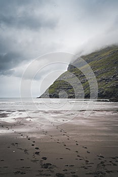 River delta with black sand beach, rocks and high cliffs in Faroe islands, close to village Saksun in Faroese island