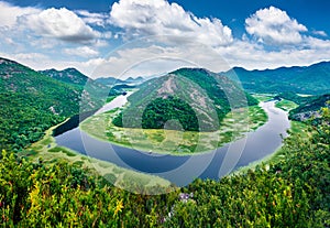 River envelops the horn peak in the ring. Aerial view of Canyon of Rijeka Crnojevica river, Skadar lake lacation. Impressive summe
