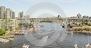 River with floating boats and boats, huge modern buildings and a bridge with moving cars, yachts at the pier