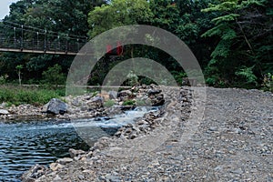 River flowing through culvert under one lane gravel road