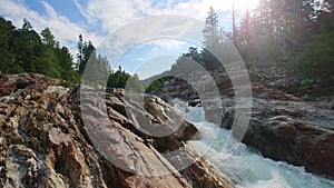 River flowing through granitic granodiorite metamorphic rocks in rocky mountains near emerald pools