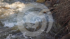 River flowing over rocks on sunny day, close up detail, rapid white water, slow motion video