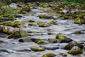 River flowing through rocks with green moss on them