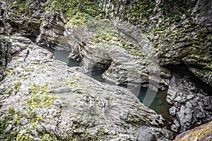 River flowing through rocky formation in outdoor cave