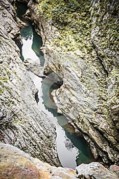 River flowing through rocky formation in outdoor cave