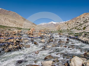 River flowing through snow cladded mountains on way to Nubra valley in Leh