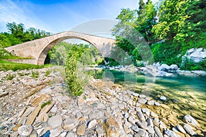 River flowing under ancient bridge