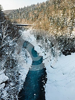 River flowing in winter mountain covered with snow.