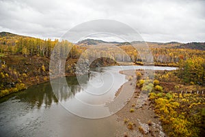 The river flows through the autumn forest.