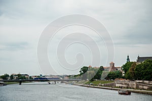 The river flows through the city. Church on the hill above the river. Wisla River in Krakow. Float the boat and the ship