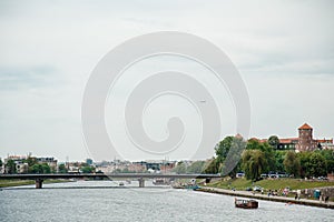 The river flows through the city. Church on the hill above the river. Wisla River in Krakow. Float the boat and the ship