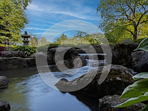 The river flows down in a cascade, the shore is lined with rocky stones