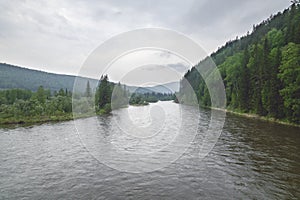 The river flows among green mountains and hills