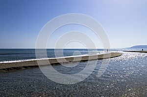 The river flows into the sea on the beach