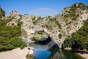 The river flows under the Pont dArc in the Gorges de lArdeche in Europe, France, Ardeche, in summer, on a sunny day