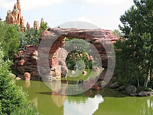 A river flows under a rock bridge in the Wild West.