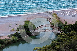 River flows underground at the sea coast, sand spit at the sandy beach, vanishing river mouth at a seaside