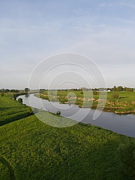 the river flows through the wild green grass