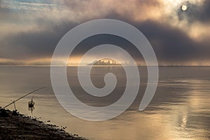 River in the fog, just before sunrise.Warm glow in the clouds from the first sunrays.