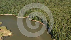 River and forest, shot from a quadcopter. Top view of a thin river and fields around it