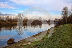 River in the italian countryside in winter with the sky casted in the water