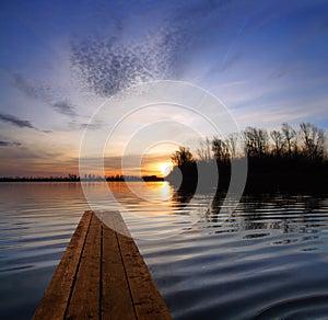 River landscape with pier and sunset on river