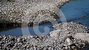 River with many stones and pebbles on the river bank