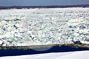 A river with melting cracked ice, snow and frozen water