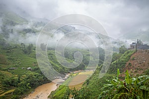 A river in the middle of green mountains, Asia, Vietnam, Tonkin, Bac Ha, towards Lao Cai, in summer, on a cloudy day