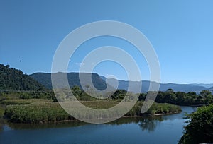 River with mountain, and blue sky background. photo