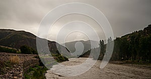 river near trees and distant mountains photo