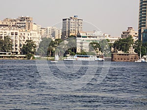 River Nile bank with a background of modern buildings on a sunny summer day and sailing boats, Cairo, Egypt