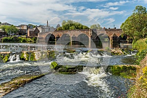 The River Nith flowing over the Caul weir in Dumfries, during summer in Scotland