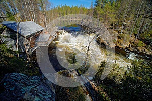River in Oulanka National Park, Finland. Summmer traveling in north of Europe. Wooden house near the river water. Waterfall in Oul photo