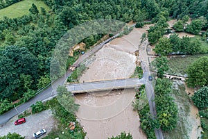 A river that overflows threatens the road bridge and property