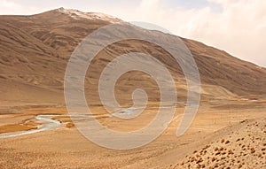 River Panj Pyandzh between Tajikistan and Afghanistan. Pamir Highway road carved in the left. Pamir Mountains