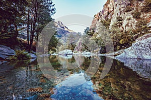 River with pebbles, mountains and picturesque forest. Enchanting and evocative landscape. photo