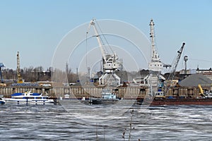 River port. The factory by the river. Sand mining. A crane and special equipment for loading sand.