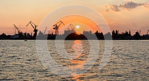 River port with ships at sunset. Busy traffic artery. Logistics and infrastructure. Loading and unloading of ships, trade traffic