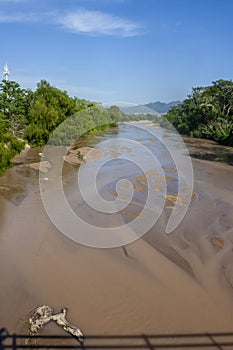A river in Puerto Vallarta viewed from a bridge downtown in dry season, Mexico photo