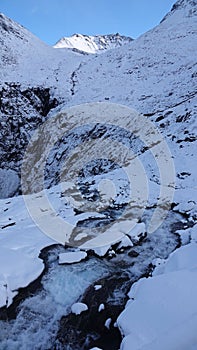 River rapids near Visitor centre on Trollstigen in snow in Norway in autumn