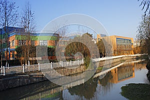 River reflecting resident house and withered willow