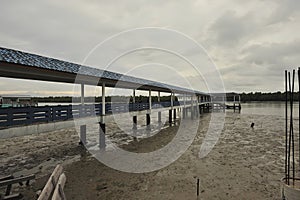 river reflection muddy water moored boat stilt houses cloudy sky