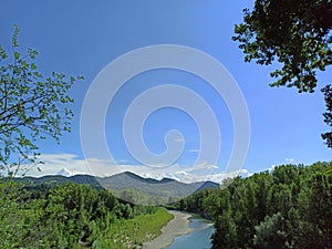 River Reno across Sasso Marconi in a triumph of wild nature and far mountains