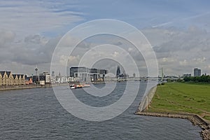 River Rine, with Kranhaus buildings on one embankment and poller wiesen green city park on the other side, cologne