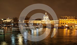 River Seine with Pont des Arts and Institut de France panorama at night in Paris, France.