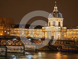 River Seine with Pont des Arts and Institut de France panorama at night in Paris, France.