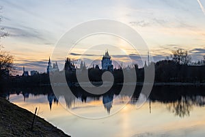 River, silhouettes of trees and towers of the Izmailovsky Kremlin in Moscow at sunset.