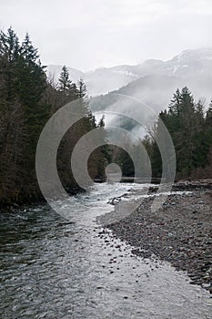 River snaking through a picturesque winter scene, with snow-dusted trees and snow-covered riverbanks