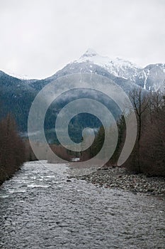 River snaking through a picturesque winter scene, with snow-dusted trees and snow-covered riverbanks